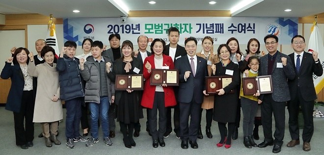 김오수 법무부장관직무대행이 모범귀화자 4명에게 기념퍠를 수여하고 기념촬영.(사진제공=법무부)