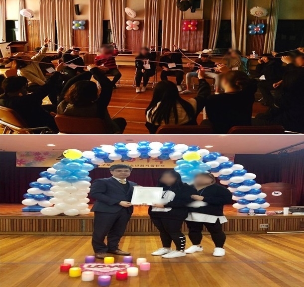 수원가정법원 윤웅기 판사가 안중걸 작가가 그린 캐리처커를 청소년들에게 전달하고 기념촬영.(사진제공=안산청소년꿈키움센터)