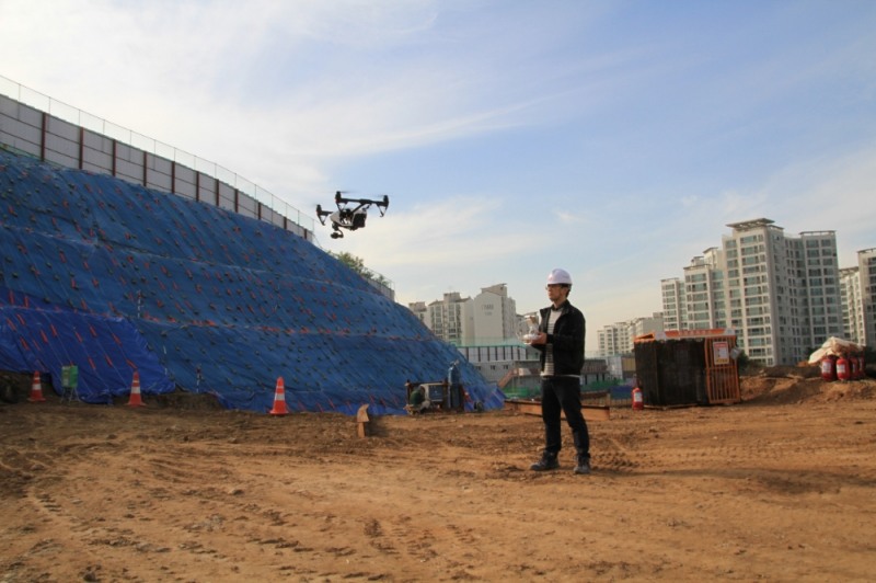 롯데건설 기술연구원 관계자가 건설 현장에서 드론으로 현장을 촬영 중이다.(사진=롯데건설)