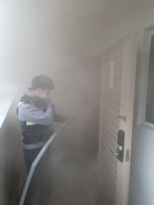 서면지구대 경찰관이 소화전을 이용해 화재를 진화하고 있다.(사진제공=부산경찰청)