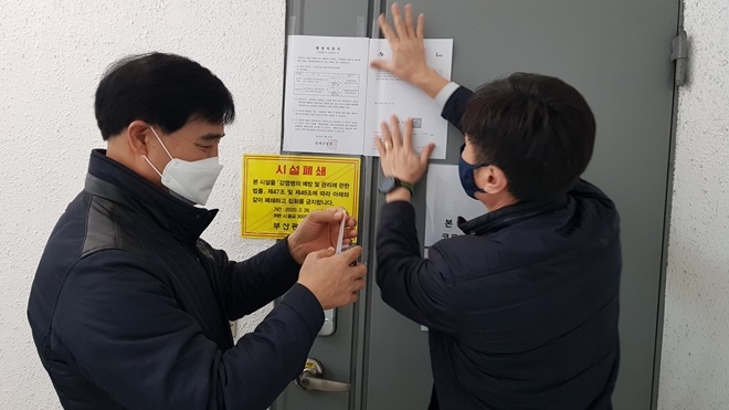2월 26일 연제구청 관계자들이 신천지 시설에 행정처분서를 붙이고 있다.(사진제공=부산연제구)