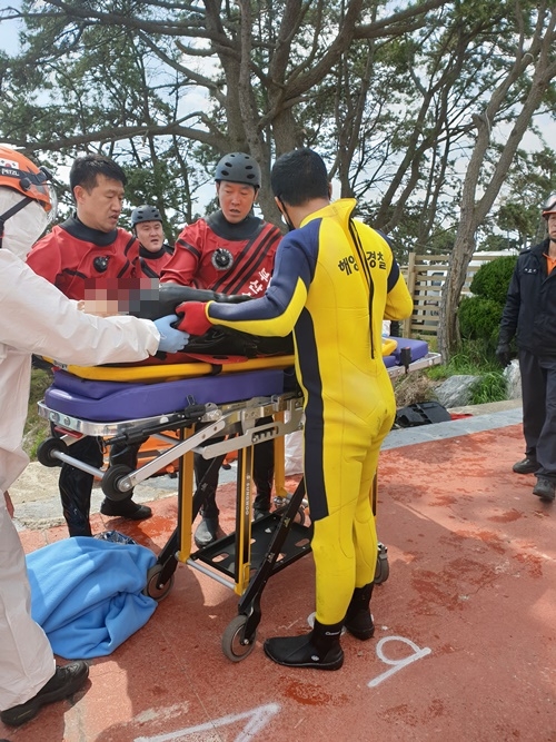 해녀를 합동 구조해 병원으로 이송하려 하고 있다.(사진제공=울산해양경찰서)