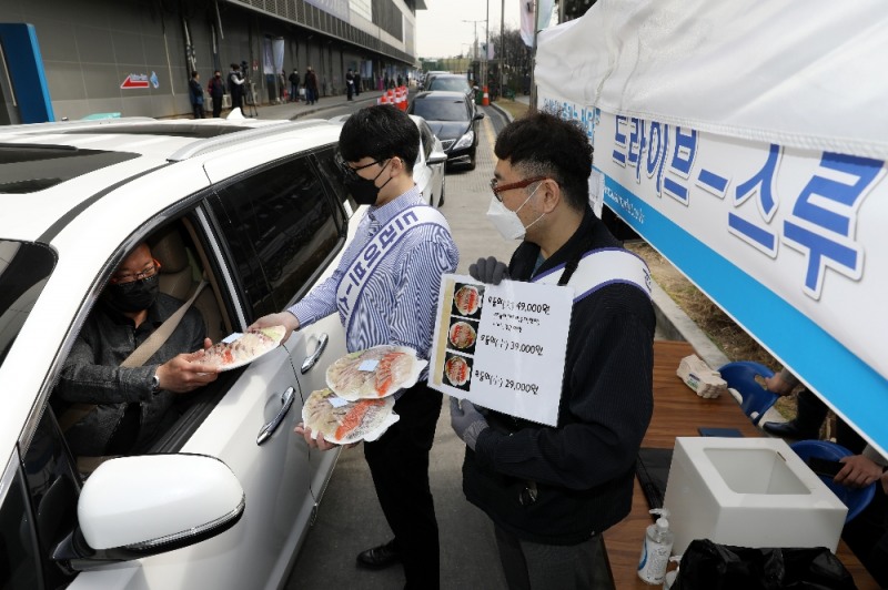서울 동작구 노량진수산시장에 설치된 드라이브 스루 판매 부스에서 직원이 차 안의 고객에게 모둠회를 건네고 있다.(사진=수협중앙회)