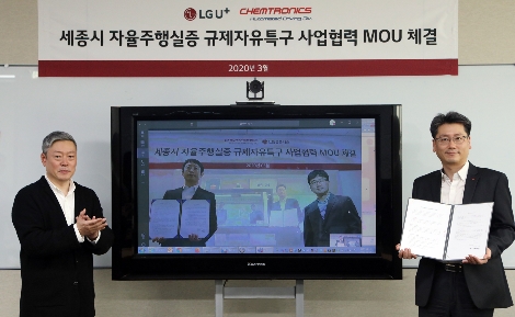 강종오 LG유플러스 모빌리티사업담당 상무(사진 우측)와 김응수 켐트로닉스 자율주행사업부문장 전무(TV속 좌측)가 원격회의를 통해 세종시 자율주행 실증 사업에 대한 업무협약을 맺는 모습. 사진=LG유플러스