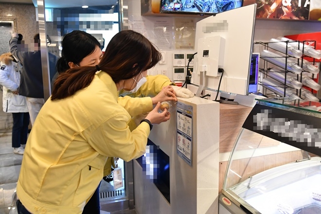 준수사항 안내지를 부착하고 있다.(사진제공=부산금정구)