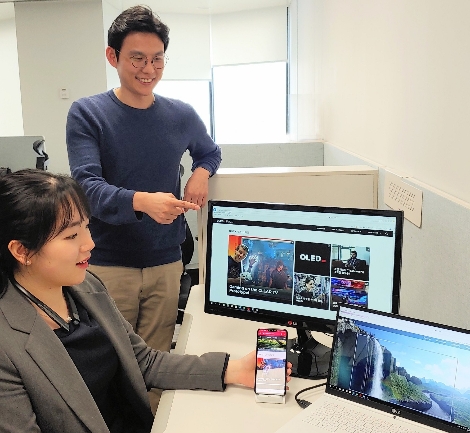 LG디스플레이 직원들이 개편된 올레드 스페이스 화면을 보고 있다. 사진=LG디스플레이