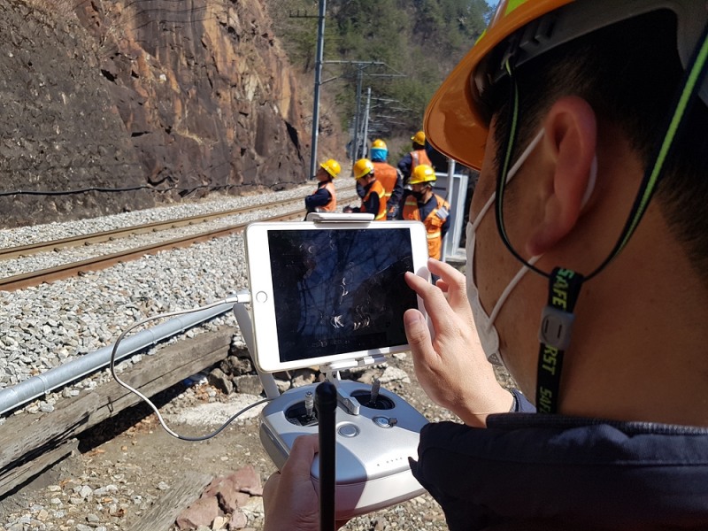 드론을 이용해 낙석 위험 구간을 점검하는 한국철도 직원들의 모습.(사진=코레일)