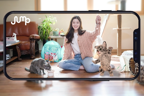 SK텔레콤 홍보모델이 스마트폰으로 실제 고양이와 AR 동물을 함께 촬영하고 있다. 사진=SK텔레콤
