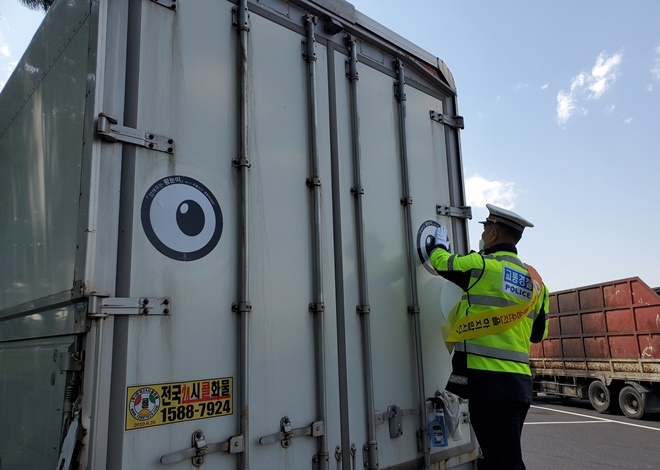 화물차후미에 '잠깨우는 왕눈이' 스티커를 부착하고 있다.(사진제공=경남경찰청)