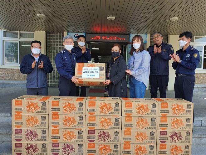 부산구치소 김성연 교정위원이 컵라면을 유태오 소장에게 전달하고 기념촬영.(사진제공=부산구치소)