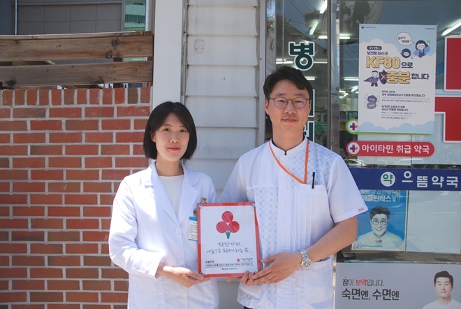 김해시 으뜸약국 약사들이 사랑의열매 로고가 새겨진 현판을 들고 기념촬영.(사진제공=경남사랑의열매)