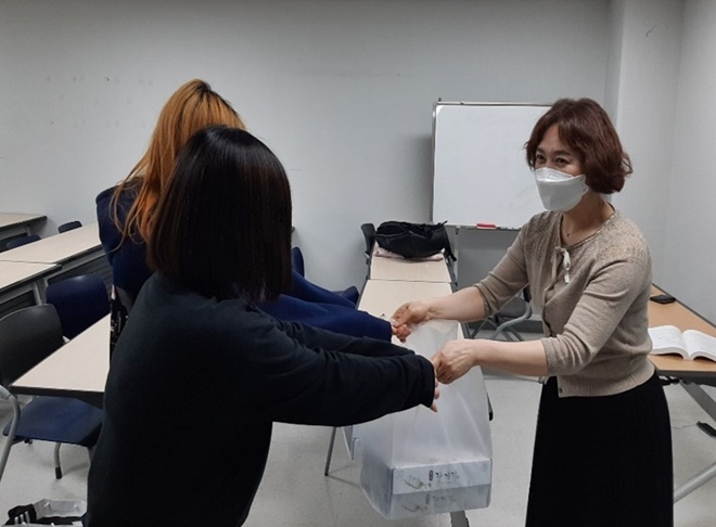 5월 23일 검정고시에 응시하는 보호관찰청소년에게 합격기원 떡을 전달하며 응원하고 있다.(사진제공=서울동부준법지원센터)