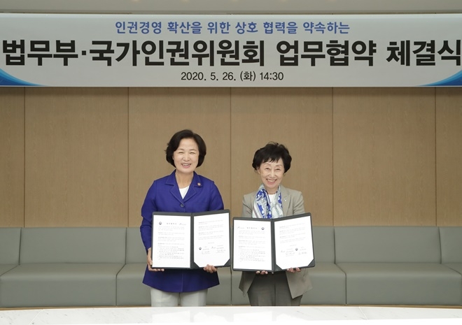 추미애 법무부장관(사진왼쪽)과 최영애 인권위원장이 협약서를 내보이며 활짝 웃고 있다.(사진제공=법무부)