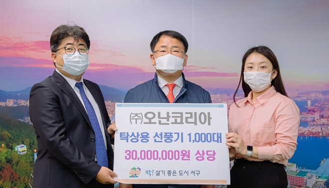 진중헌 대표(사진왼쪽)가 공한수 구청장에게 탁상용 선풍기 1000대를 기탁하고 기념촬영.(사진제공=부산 서구)