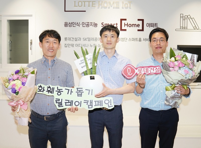 롯데건설 대구 C/S센터 근무자들이 꽃다발과 공기정화 식물이 담긴 화분을 들고 사진을 찍고 있다.(사진=롯데건설)