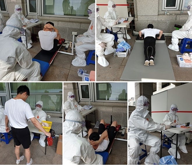 19일 오전 코로나19예방을 위해 발열체크 등 청사 밖 실외장소에서 1차 순경필기시험 합격자 24명이 체력검사를 하고 있다.(사진제공=부산경찰청)