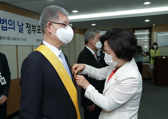 1추미애 법무부 장관(오른쪽)이 24일 정부과천청사에서 개최된 ‘제57회 법의 날 유공 정부포상 전수식’에서 대한변호사협회 김주덕 변호사에게 국민훈장 무궁화장을 전수하고 있다.(사진제공=법무부)