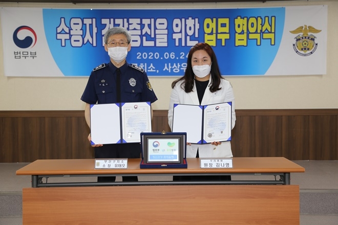 유태오 소장과 김나영 원장이 업무협약서를 내보이며 기념촬영.(사진제공=부산구치소)