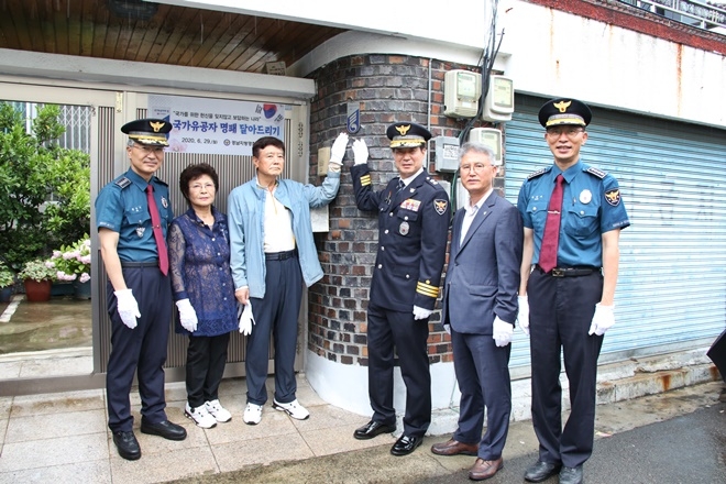 29일 경찰출신 월남참전국가유공자 심병시 씨 자택에 국가유공자 명패를 부착하고 기념촬영.(사진제공=경남경찰청)