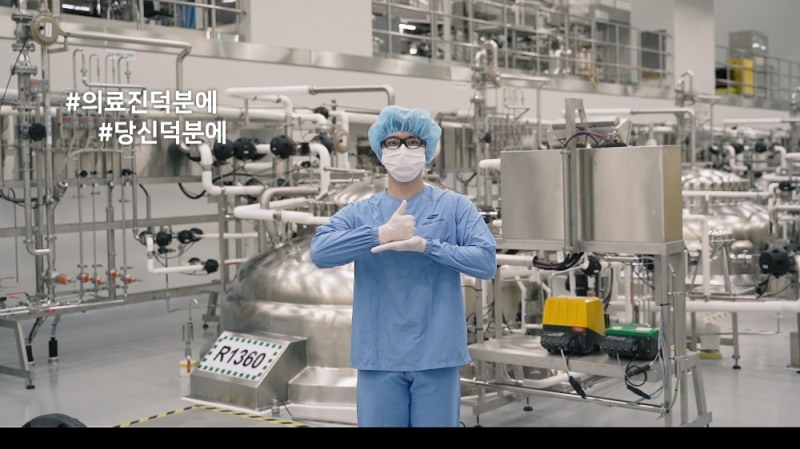 삼성바이오로직스가 22일 코로나19 확산 방지에 헌신하고 있는 의료진과 소방대원에게 감사와 응원의 마음을 전하는 #덕분에 챌린지에 참여했다. 삼성바이오로직스의 한 직원이 인천 송도에 위치한 삼성바이오로직스 2공장에서 고마움과 존경을 의미하는 수어를 하고 있다.