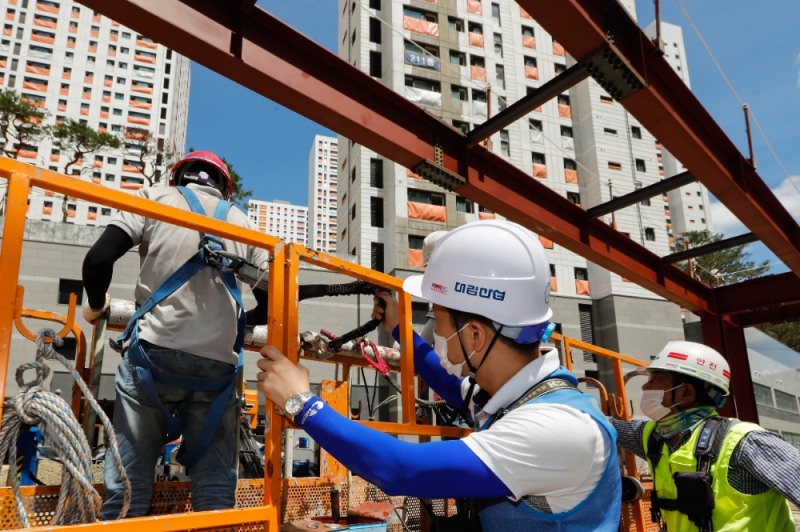 e편한세상 금정산 현장에서 대림산업 안전관리자와 협력회사 직원들이 안전벨트를 비롯한 보호구 착용을 점검하고 있다.(사진=대림산업)
