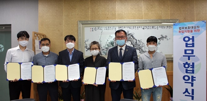 법무보호대상자들의 일자리 창출을 위한 업무협약서를 내보이며 기념촬영. (사진제공=한국법무보호복지공단 경남지부)