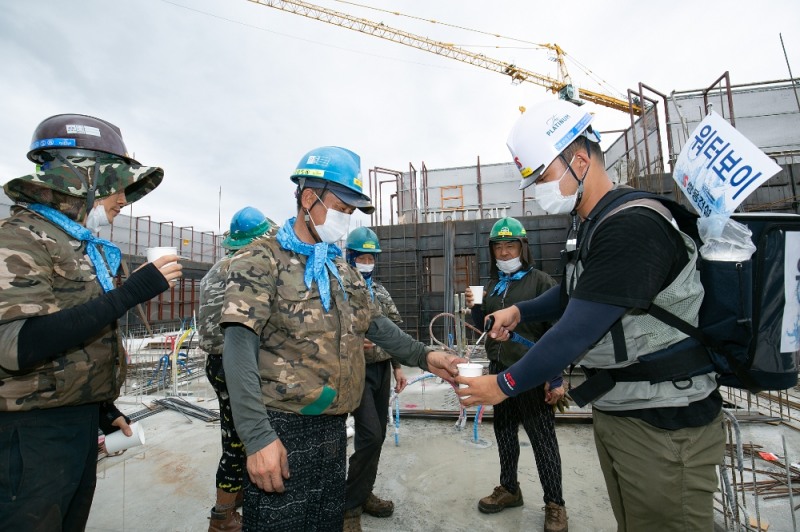 물탱크를 맨 워터보이로 변신한 안전보건관리자가 근로자들에게 시원한 물을 제공해주고 있다.(사진=쌍용건설)