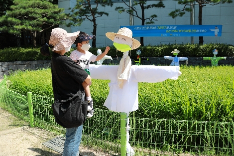 한 시민이 아이와 함께 서울시 중구 농업박물관 야외체험장에 설치된 허수아비를 관람하고 있다. 사진=농협중앙회
