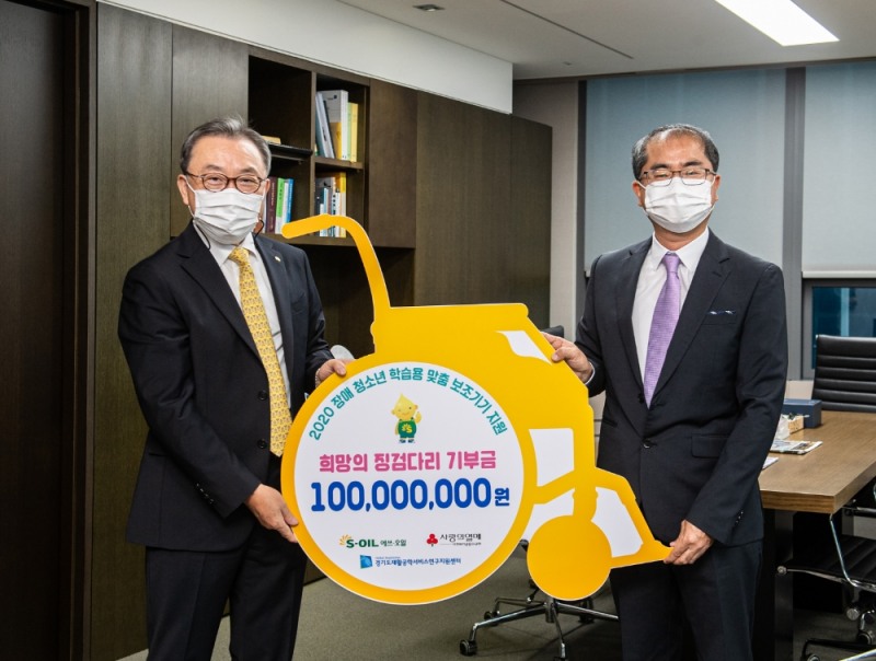 에쓰오일 조영일 수석부사장(왼쪽)이 17일 서울 마포 본사에서 강인학 경기도 재활공학서비스연구지원센터장에게 장애 청소년 학습용 맞춤 보조기구를 전달하고 기념촬영을 하고 있다.(사진=에쓰오일)