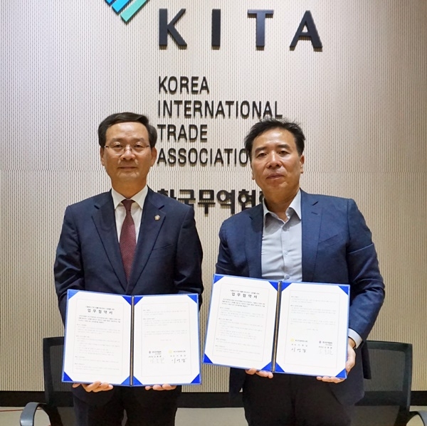이영갑 부산지방변호사회장(사진왼쪽)과 김종환 한국무역협회 부산지역본부장이 협약서를 내보이며 기념촬영.(사진제공=부산지방변호사회)