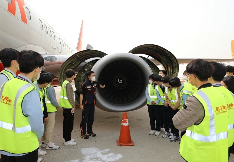 28일 제주항공 정비본부를 방문한 항공특성화고등학교 학생들이 정비사에게 항공기에 대한 설명을 듣고 있다.(사진=제주항공)