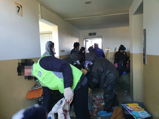 사회봉사대상자들이 저장강박 세대에서 적치물을 치우고 있다.(사진제공=부산서부준법지원센터)