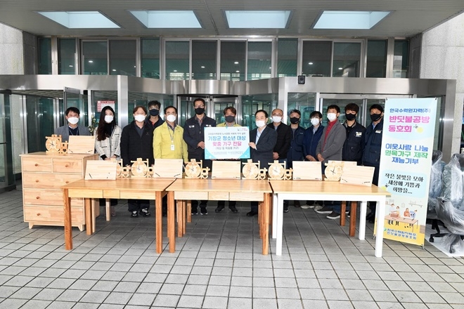 한수원 반딧불 공방 동호회가 18일 기장군에 직접 제작하 책상, 서랍장 등을 기장군에 기증하고 기념촬영.(사진제공=부산 기장군)