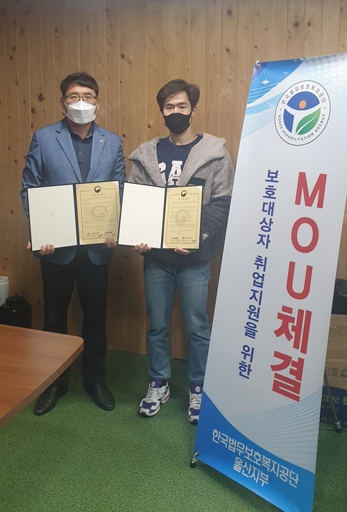 보호복지공단울산지부 김주병 지부장과 다이몬 박효근 대표가 12월 4일 업무협약서를 내보이며 기념촬영.(사진제공=한국법무보호복지공단울산지부)