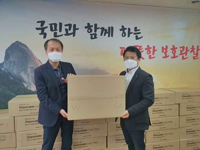 배종상 소장(왼쪽)이 김영규 보호관찰위원(우측)으로부터 일회용 마스크 5만여 개를 기증받고 기념촬영.(사진제공=서울북부준법지원센터)