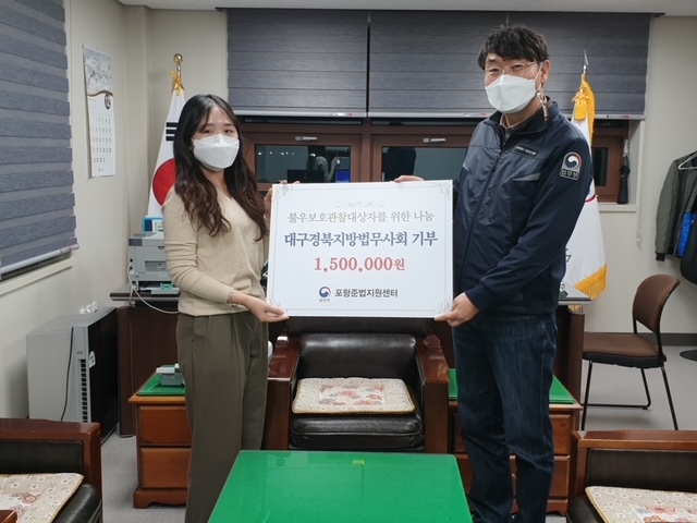 대구경북지방법무사회 장성숙 포항지부장이 150만원의 성금을 포항준법지원센터 양병곤 소장에게 전달하고 기념촬영.(사진제공=포항준법지원센터)