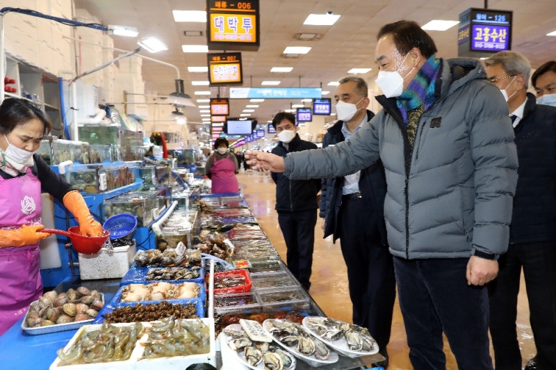 임준택 수협중앙회장(사진 우측)이 12일 노량진수산시장에서 수산물 판매장을 둘러보고 패류를 직접 구입하고 있다.(사진=수협중앙회)