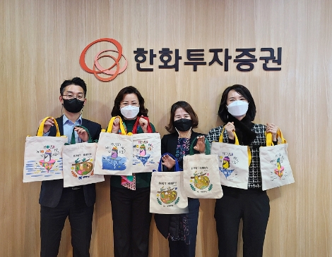 한화투자증권 임직원들이 집에서 제작한 기부물품을 들고 사진촬영을 하고있다. 사진=한화투자증권