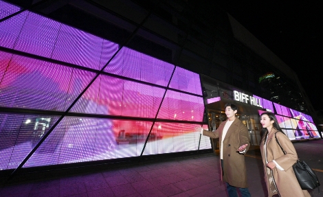 LG전자 모델들이 투명 LED 필름이 설치된 영화의전당 주변 경관을 소개하고 있다. 사진=LG전자