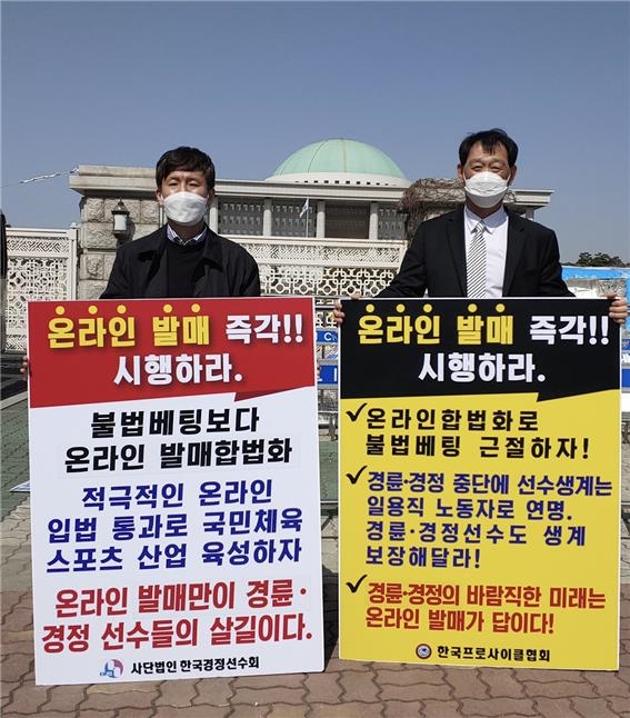 박상현 한국경정선수회장(왼쪽)과 박종현 한국프로사이클협회장이 경륜경정 온라인 발매를 촉구하는 1인 시위를 국회 앞에서 하고 있다. (사진=국민체육진흥공단)