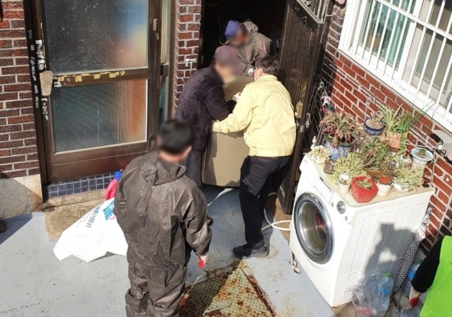 저장강박 세대의 적치물을 치우고 있다.(사진제공=부산서부준법지원센터)