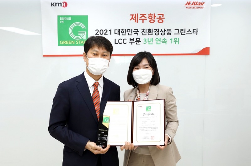 지난 20일 오후 서울 영등포구에 위치한 한국경영인증원에서 제주항공 이철행 상무가 황은주 원장(사진 오른쪽)과 함께 인증서와 패를 들고 기념촬영을 하고 있다.(사진=제주항공)