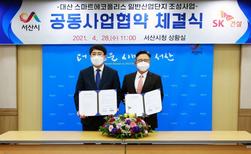 박경일 SK건설 사업운영총괄(오른쪽)과 맹정호 서산시장이 협약서를 들고 기념촬영을 하고 있는 모습.(사진=SK건설)