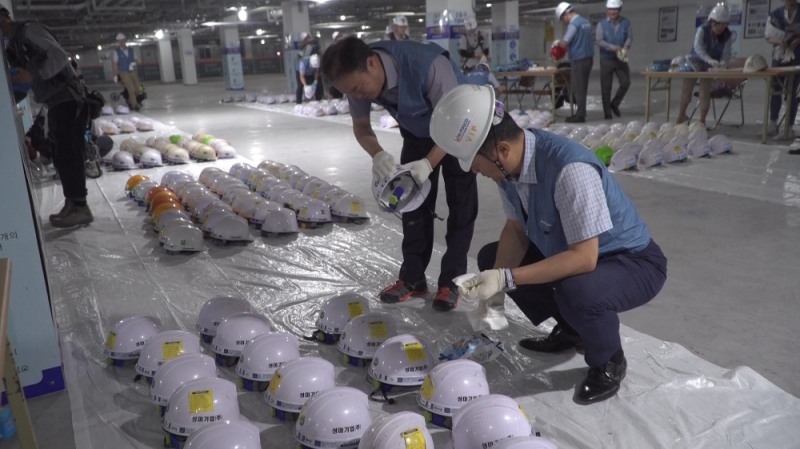 포스코건설 직원들이 협력사 근로자들의 안전모 클리닝을 하고 있다.(사진=포스코건설)