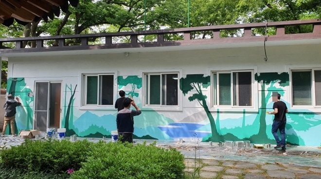 벽화 특기를 가진 사회봉사대상자들이 금정구 조리마을의 노인회관 및 마을의 노후된 벽에 생기를 불어넣고 있다.(사진제공=부산동부준법지원센터)