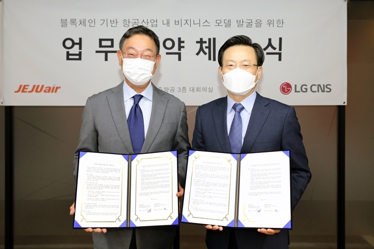 업무협약 체결식’에서 제주항공 김이배 대표(사진 오른쪽)와 LG CNS 현신균 부사장(사진 왼쪽)이 기념사진 촬영을 하고 있다.(사진=제주항공)
