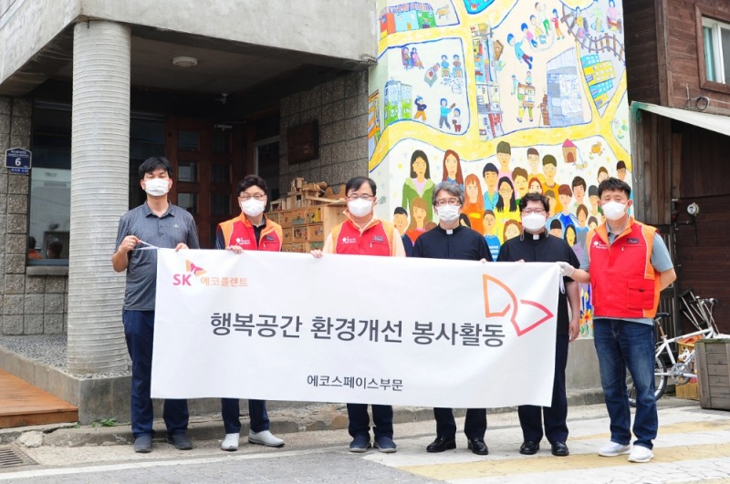 양재웅 SK에코플랜트 에코스페이스OXG장(왼쪽 세번째)이 환경개선이 완료된 건물 앞에서 기념촬영을 하는 모습.(사진=SK에코플랜트)