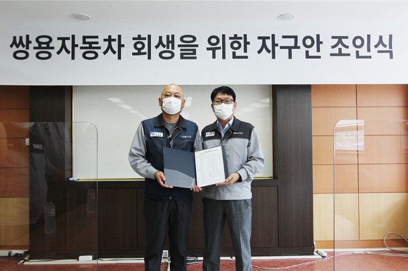 정용원 관리인(사진 오른쪽)과 정일권 노동조합 위원장이 합의안에 서명한 후 기념촬영을 하고 있다.(사진=쌍용자동차)