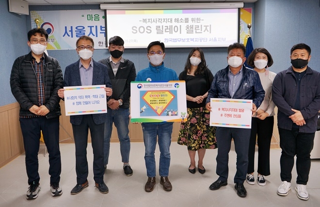 김덕환 지부장(사진왼쪽 세번째) 등 직원들이 복지사각지대 해소 SOS릴레이 챌린지에 동참하고 있다.(사진제공=한국법무보호복지공단 서울지부)