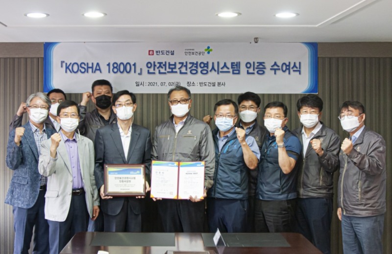 반도건설 박현일 대표(왼쪽 여섯 번째), 안전보건공단 정완순 본부장(왼쪽 다섯 번째)과 양사 임직원들이 안전보건경영시스템 ‘KOSHA 18001’인증 수여식 기념촬영을 하고 있다.(사진=반도건설)